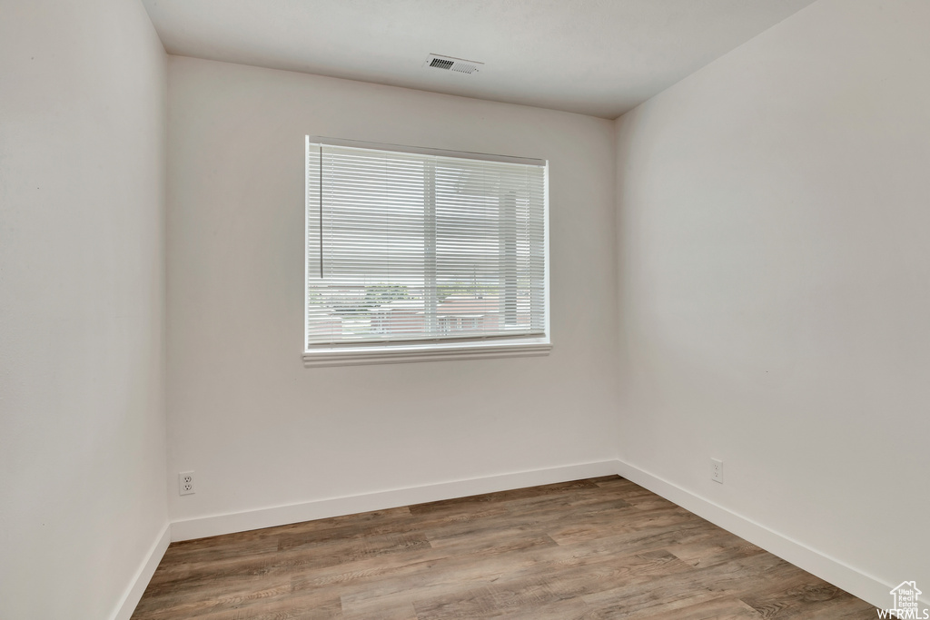 Unfurnished room with baseboards and wood finished floors