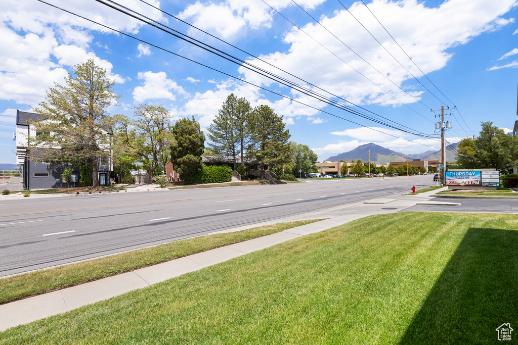View of asphalt street with sidewalks and a mountain view