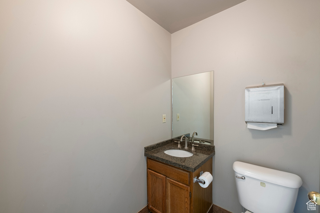Half bathroom featuring vanity and toilet