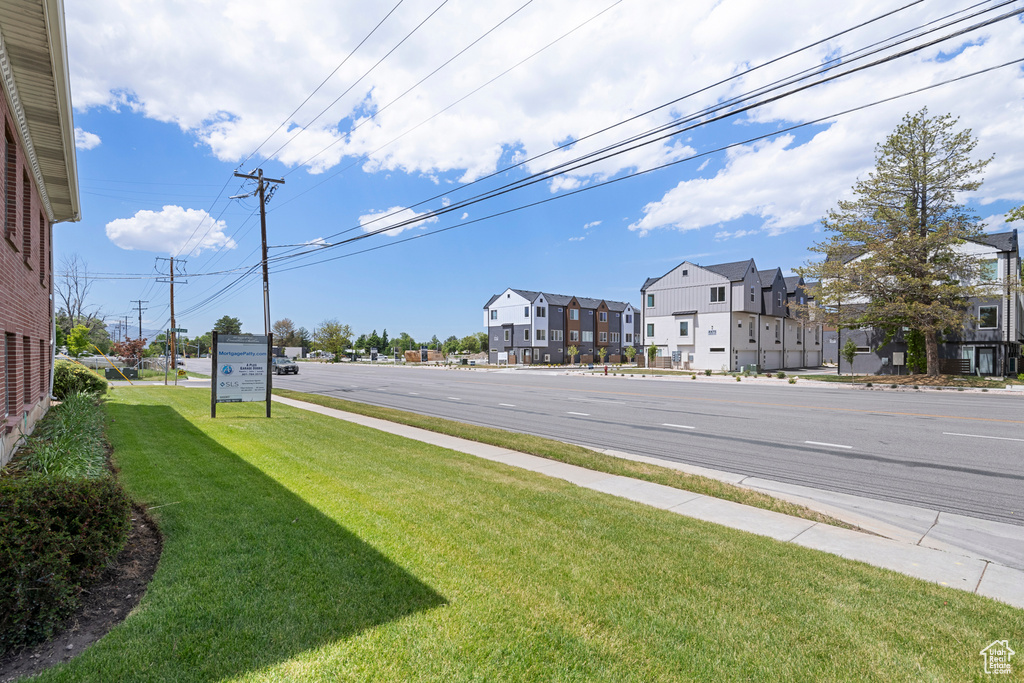 View of asphalt road featuring sidewalks and a residential view