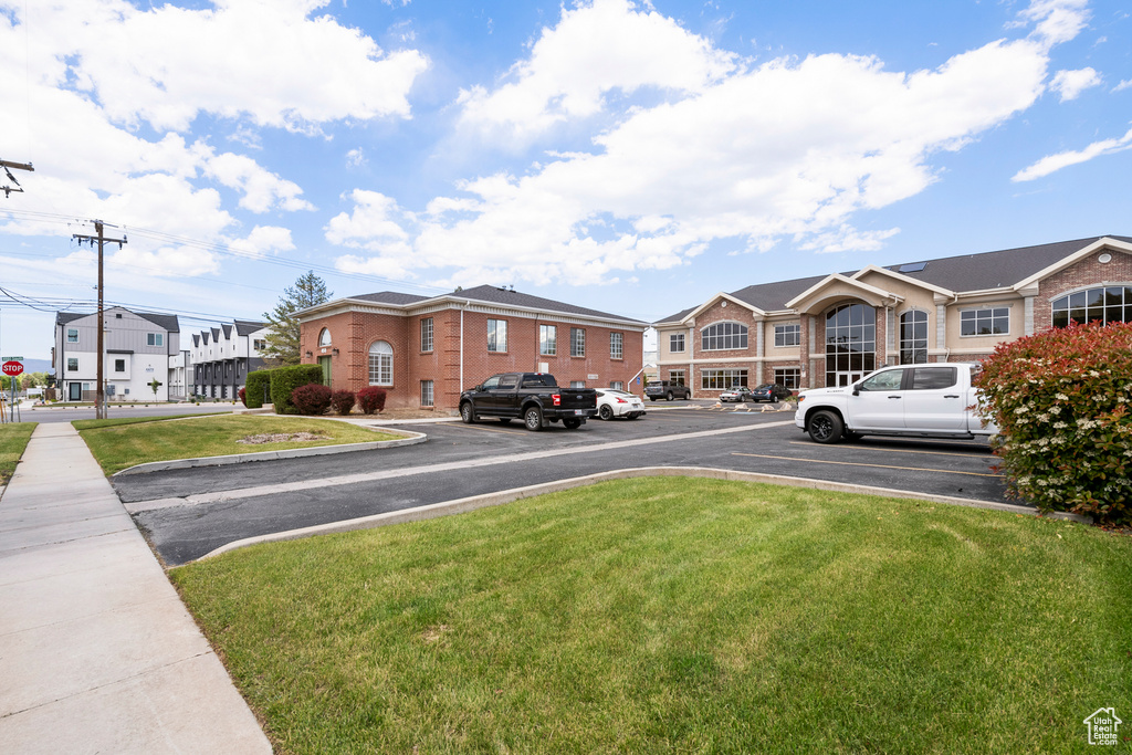 View of asphalt street with curbs, a residential view, sidewalks, and traffic signs