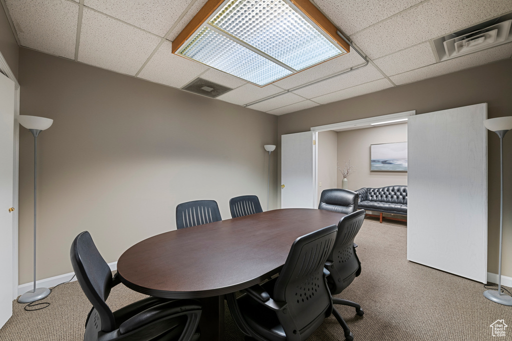 Office area featuring a drop ceiling, carpet, and baseboards