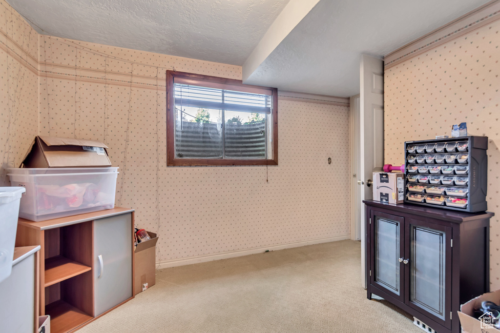 Interior space featuring wallpapered walls, carpet, and a textured ceiling