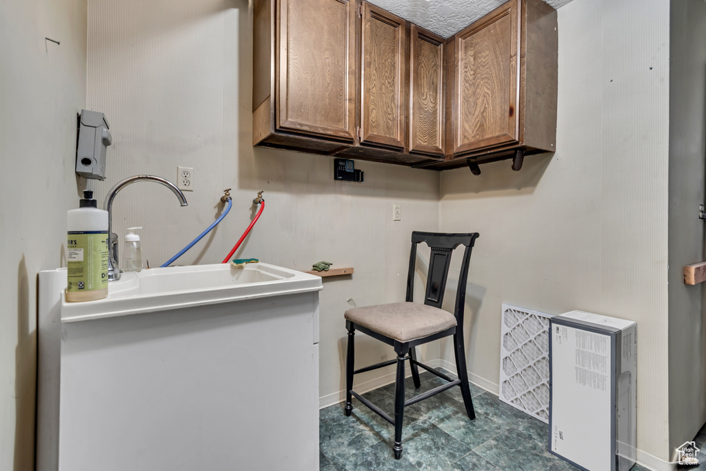 Laundry room featuring washer hookup, baseboards, and cabinet space