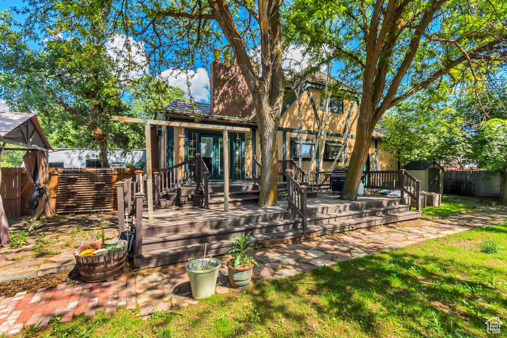 Rear view of property with a fenced backyard and a deck
