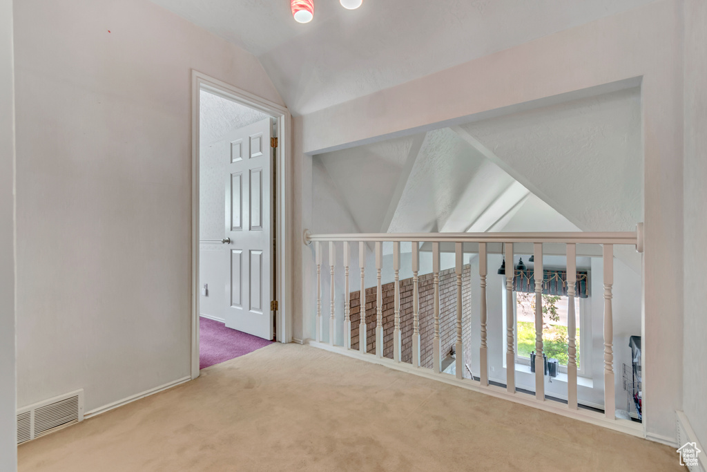 Hall featuring carpet, lofted ceiling, and baseboards