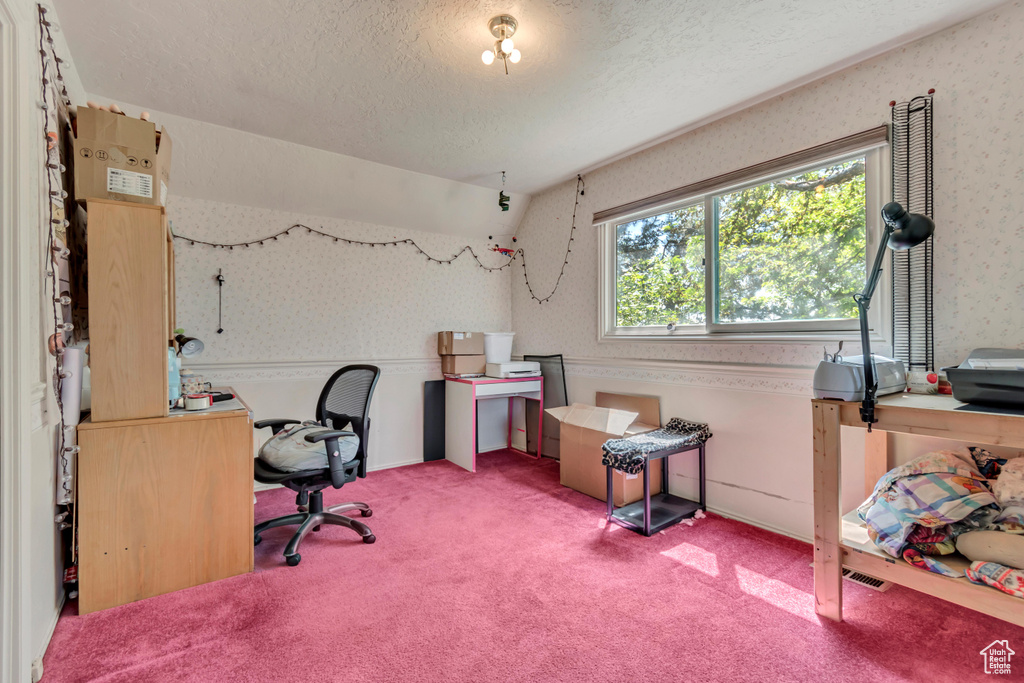 Office space with wallpapered walls, a textured ceiling, and light colored carpet