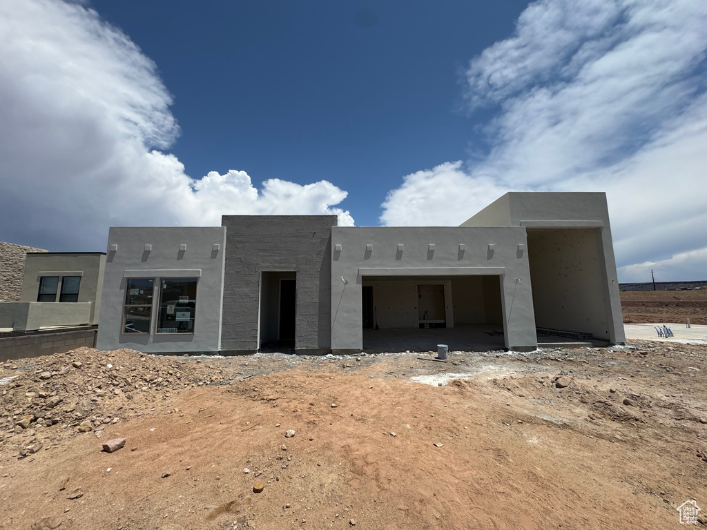 Pueblo revival-style home featuring a garage