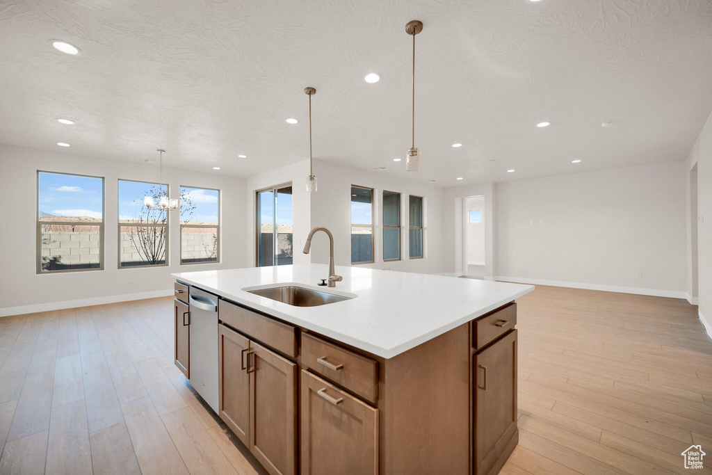 Kitchen featuring a sink, baseboards, open floor plan, dishwasher, and recessed lighting