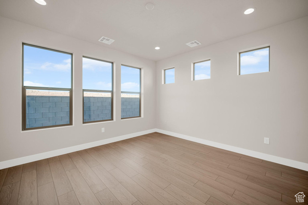Empty room featuring baseboards, wood finished floors, and recessed lighting