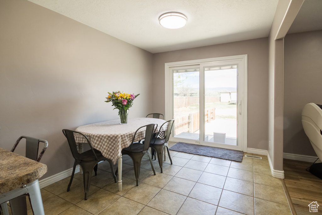 Dining space with baseboards and light tile patterned floors