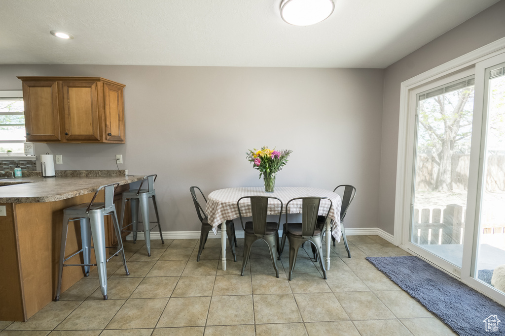Dining area with baseboards, light tile patterned floors, and recessed lighting