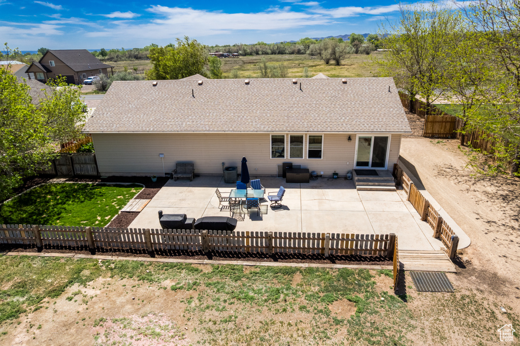 Back of property featuring a patio area and roof with shingles
