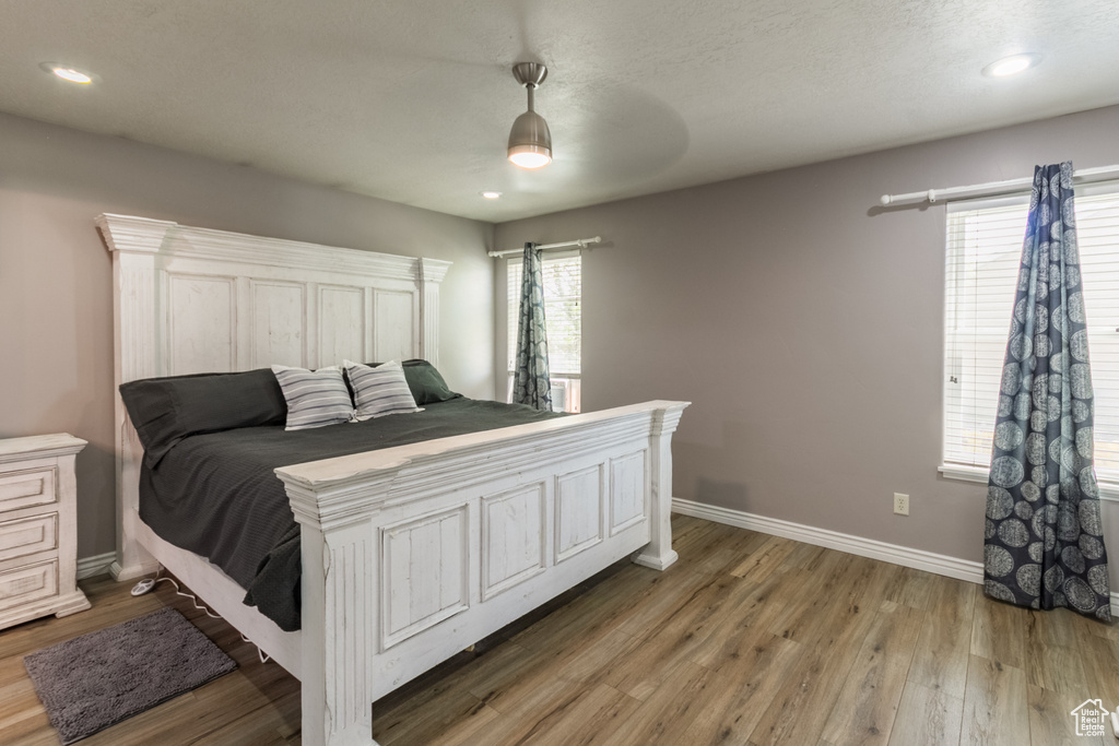 Bedroom featuring baseboards, light wood-style floors, a ceiling fan, and recessed lighting
