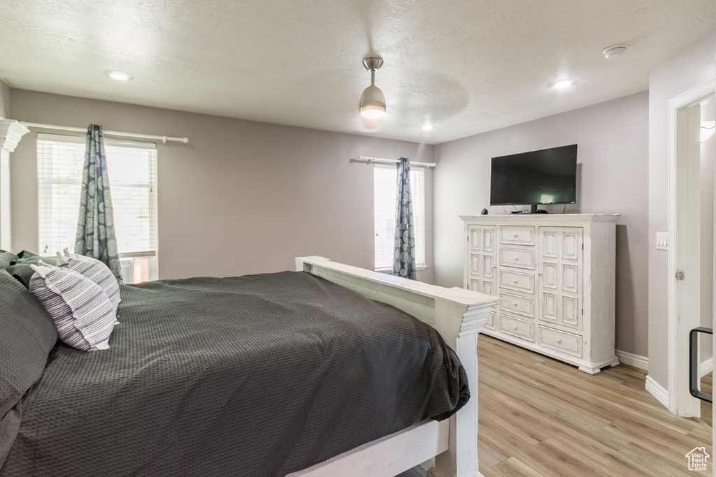 Bedroom featuring light wood-style flooring, ceiling fan, recessed lighting, and baseboards
