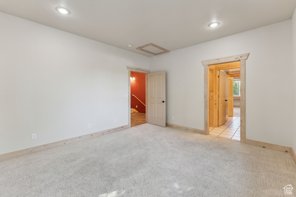 Carpeted empty room with attic access, recessed lighting, and baseboards