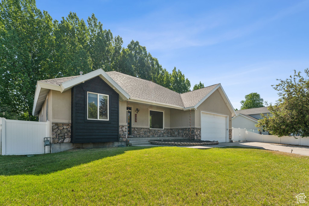 Ranch-style house featuring stone siding, driveway, a garage, stucco siding, and covered porch