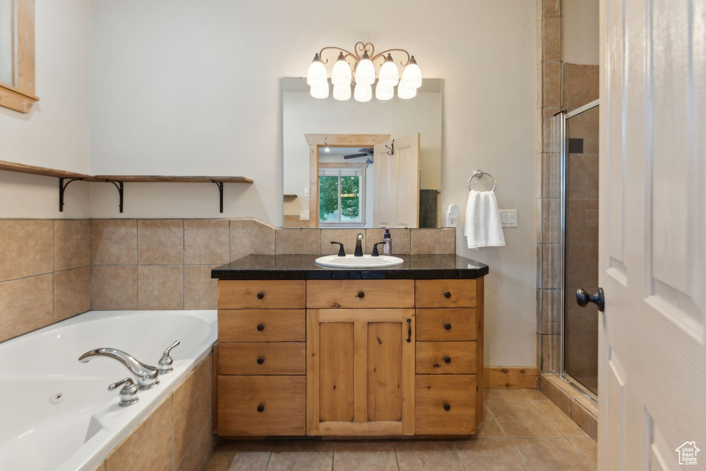 Full bathroom featuring vanity, a stall shower, a tub with jets, and tile patterned flooring