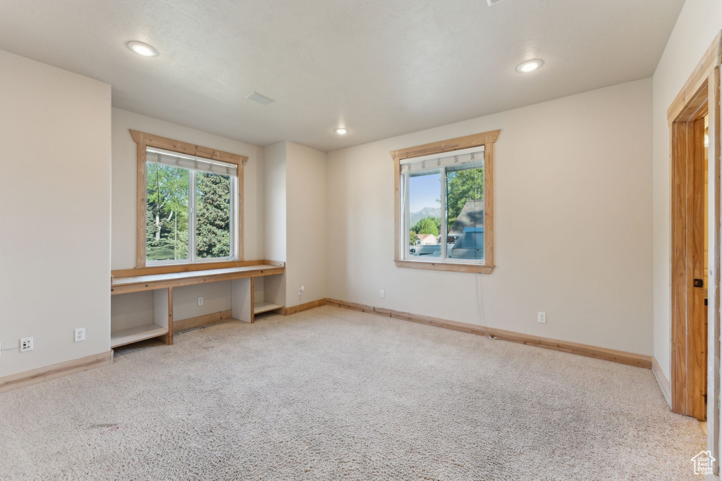 Unfurnished bedroom with multiple windows, carpet floors, recessed lighting, and baseboards