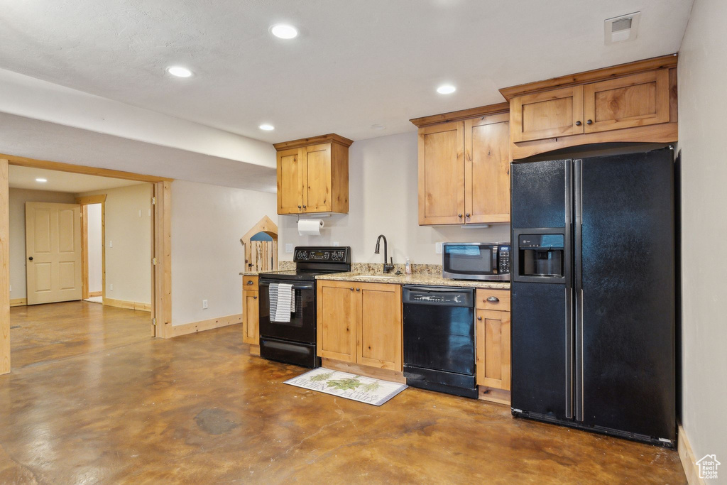 Kitchen featuring black appliances, concrete floors, recessed lighting, baseboards, and a sink