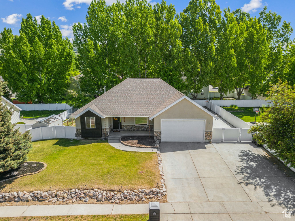 View of front of home featuring stone siding, a garage, driveway, covered porch, and a shingled roof