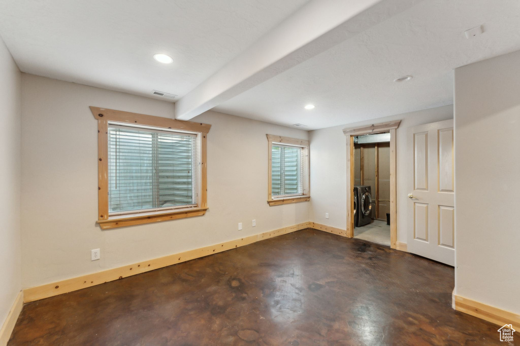 Empty room with independent washer and dryer, concrete floors, baseboards, recessed lighting, and beamed ceiling