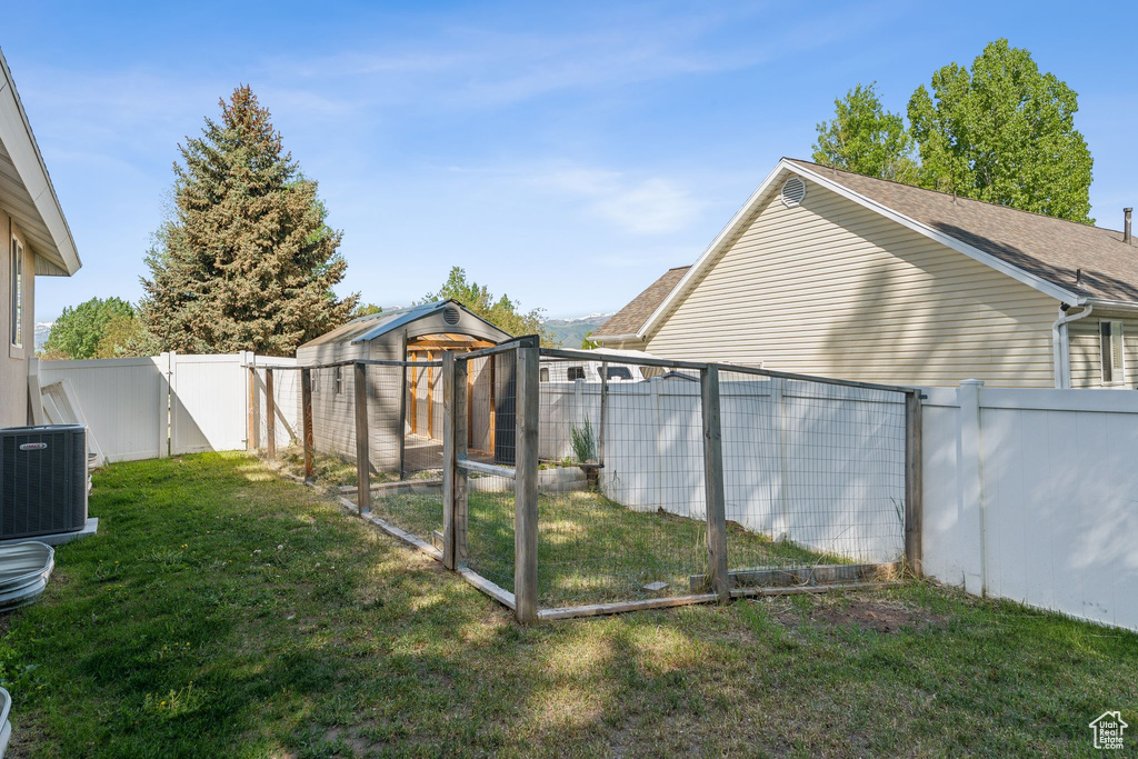 View of yard with a gate and central AC