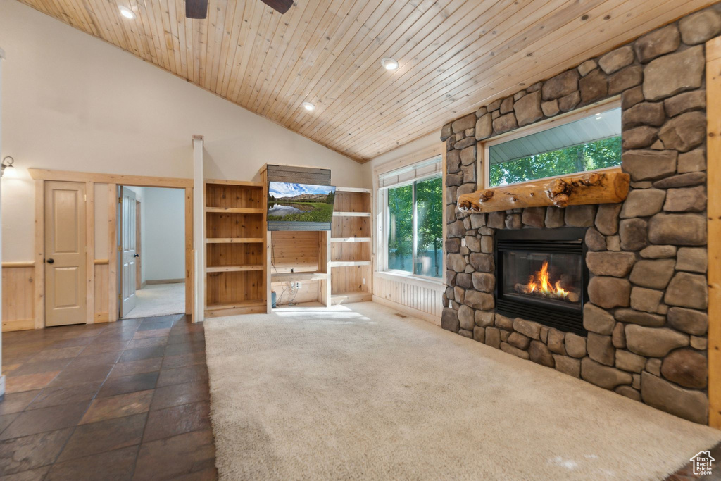 Unfurnished living room featuring a stone fireplace, recessed lighting, high vaulted ceiling, a ceiling fan, and wood ceiling