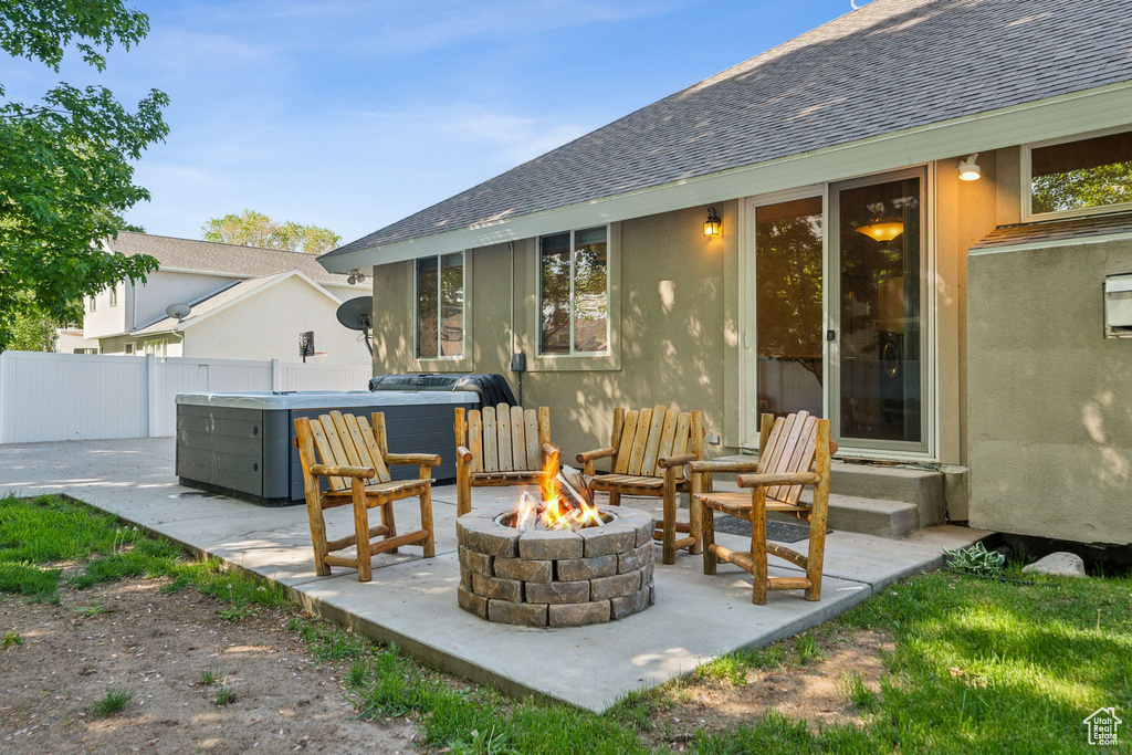 View of patio / terrace with a fire pit and a hot tub