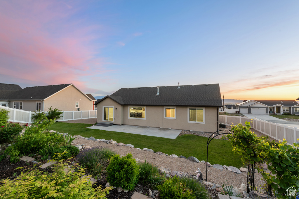 Rear view of property with a patio area, stucco siding, and a shingled roof