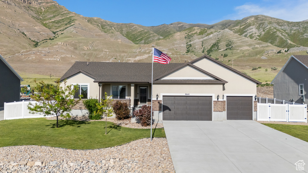 Single story home with stucco siding, a garage, a gate, and concrete driveway