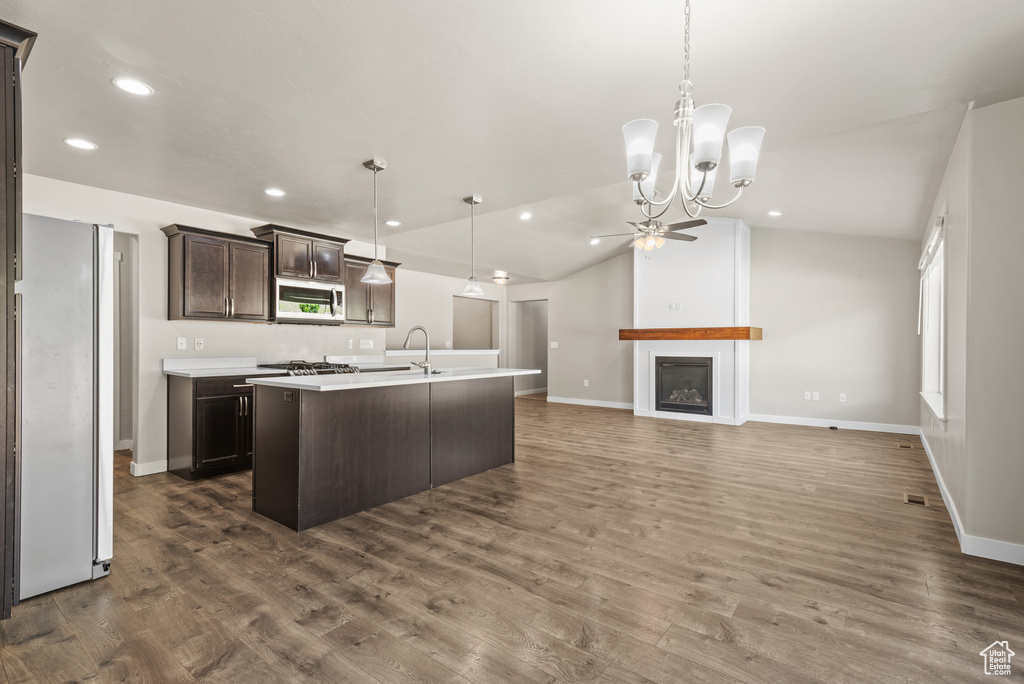 Kitchen featuring appliances with stainless steel finishes, dark brown cabinetry, recessed lighting, light countertops, and a kitchen island with sink