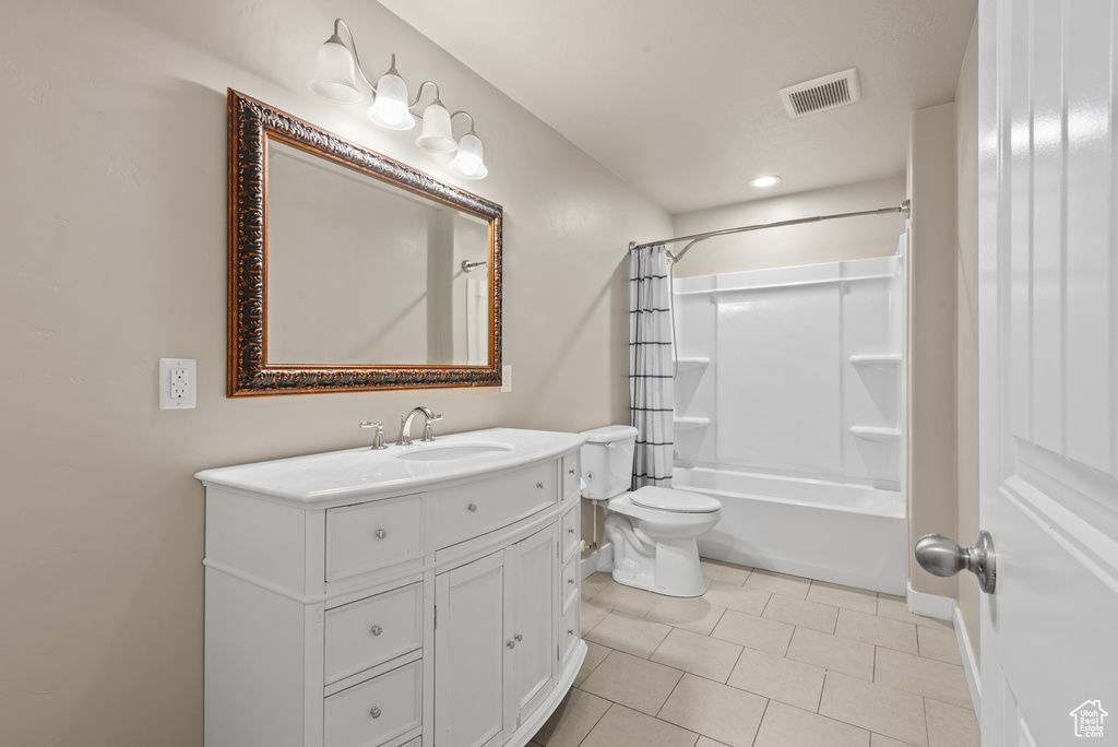 Full bath featuring vanity, toilet, shower / bath combo with shower curtain, tile patterned floors, and recessed lighting