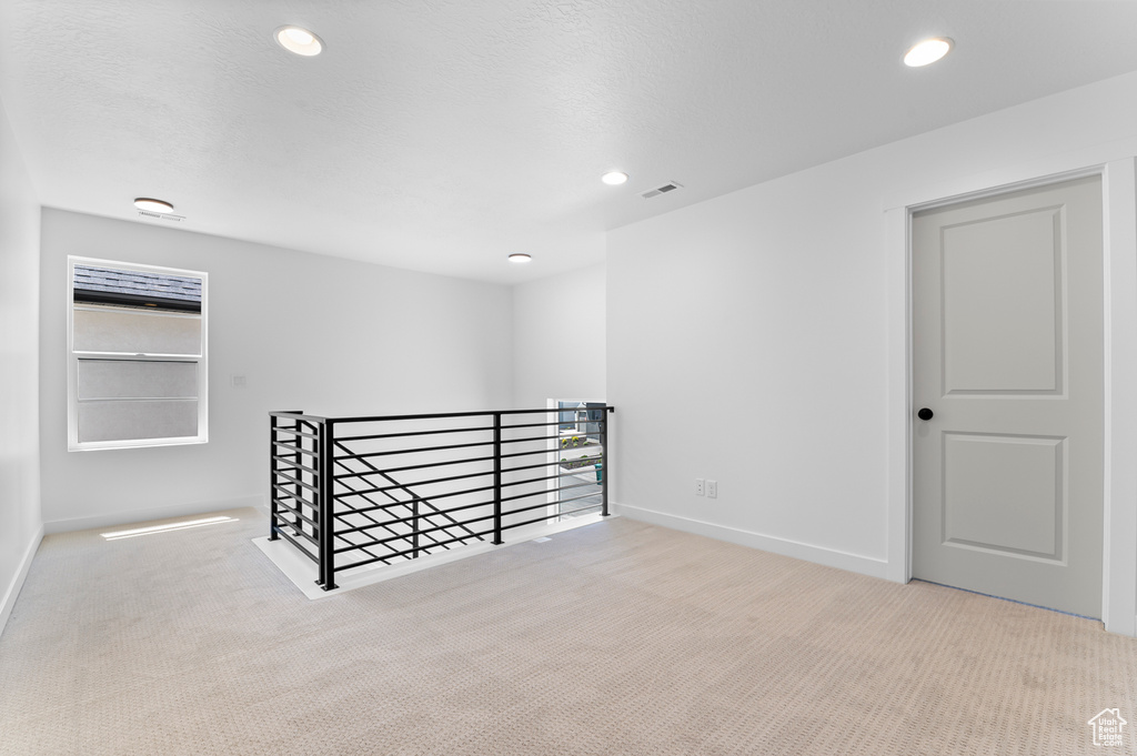 Empty room featuring carpet flooring, recessed lighting, and baseboards