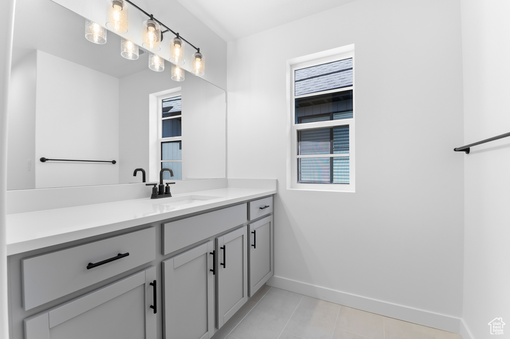 Bathroom featuring vanity, baseboards, and tile patterned flooring