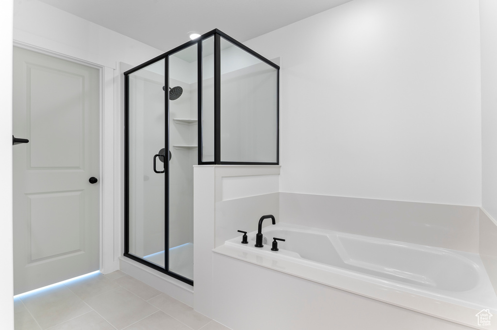 Full bath with a stall shower, a garden tub, and tile patterned floors