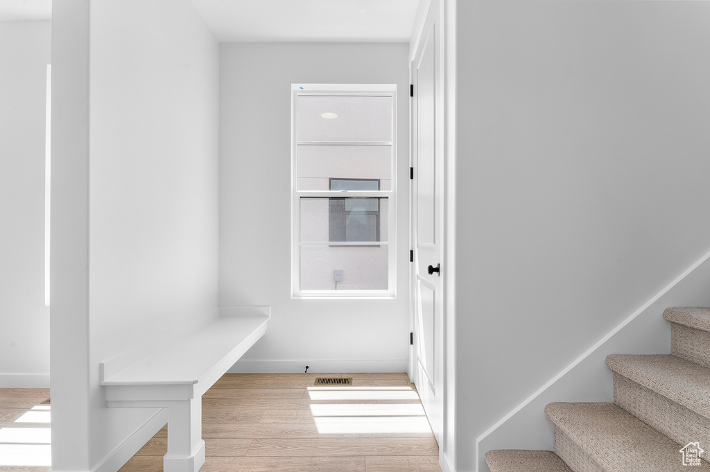 Stairs with wood finished floors and baseboards