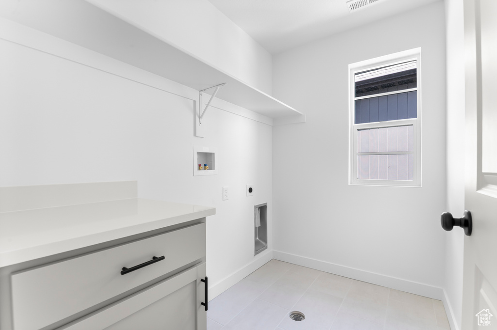 Laundry room with hookup for a washing machine, hookup for an electric dryer, baseboards, and cabinet space