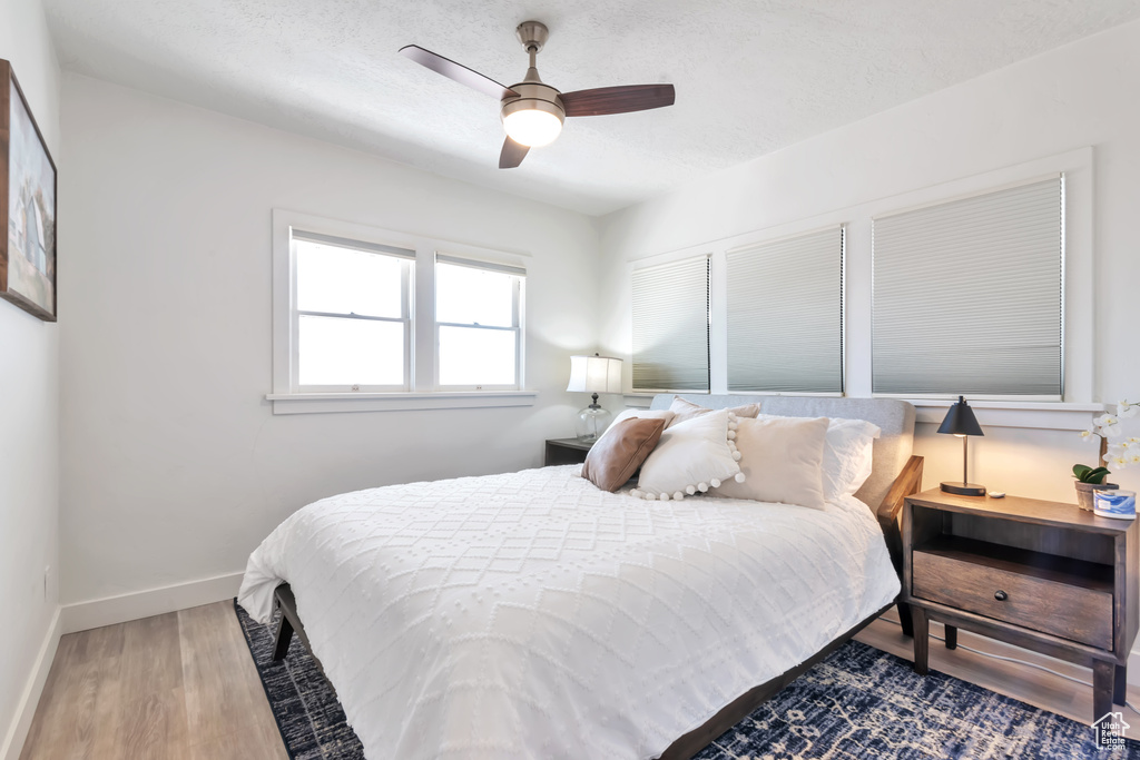 Bedroom featuring hardwood / wood-style flooring, a textured ceiling, and ceiling fan