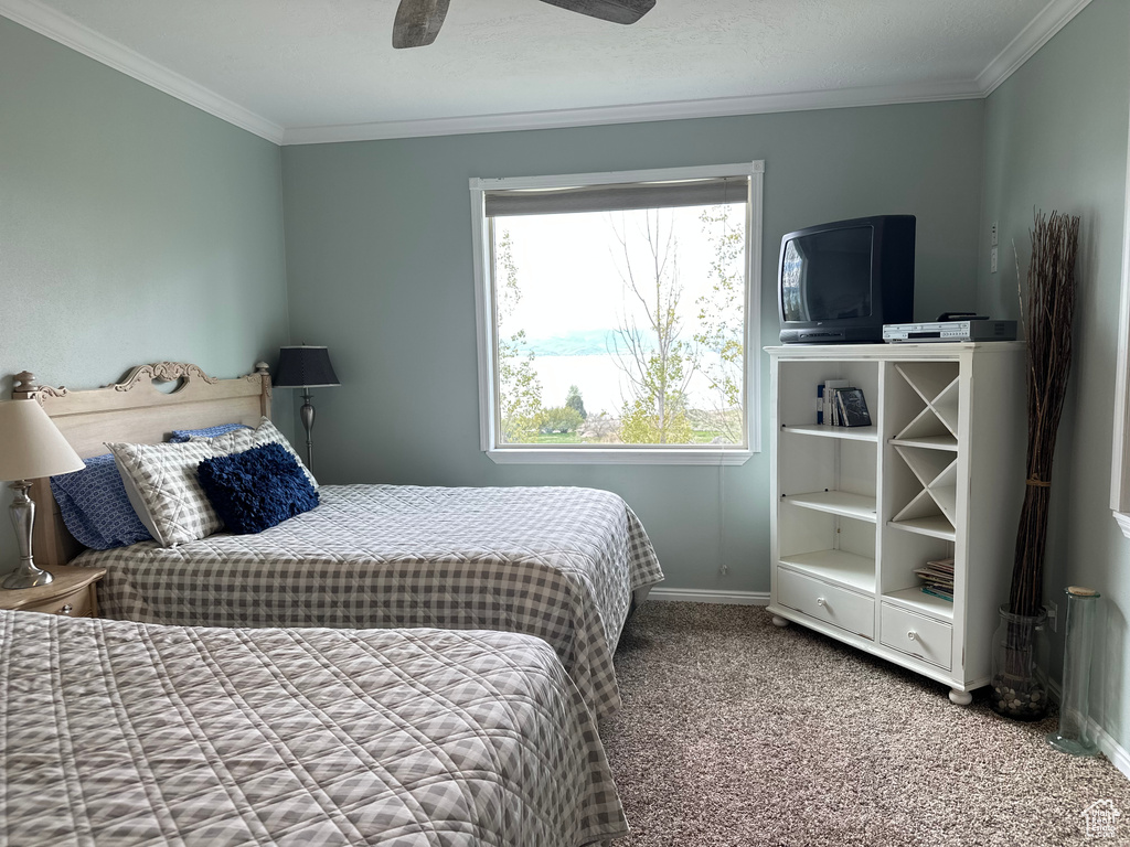 Bedroom with crown molding, baseboards, carpet floors, and ceiling fan