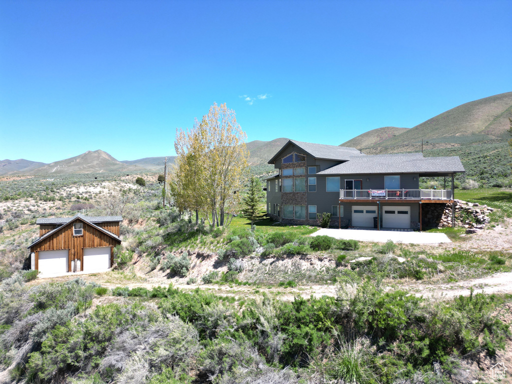 View of front of home with a garage and a deck with mountain view