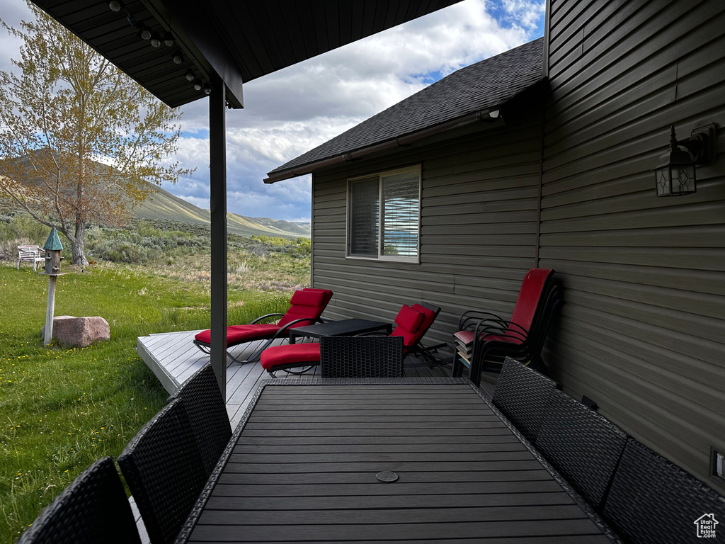Wooden terrace featuring a yard and a mountain view