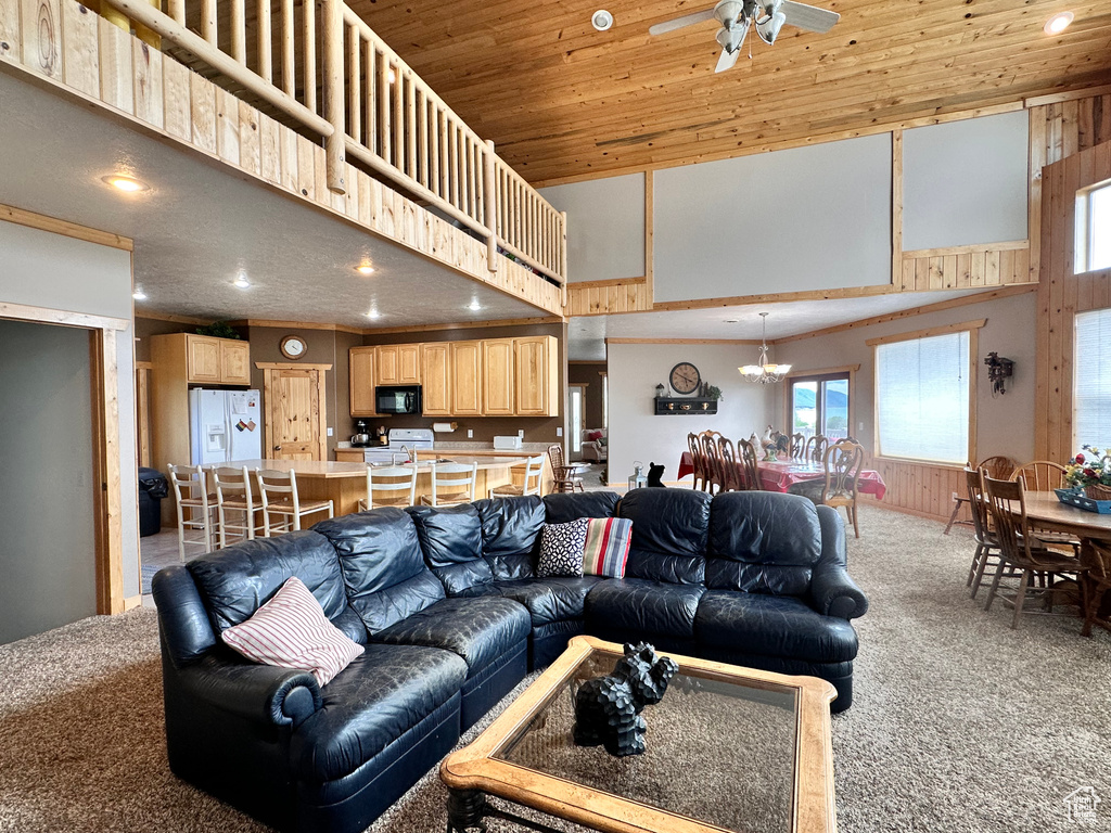 Living area with carpet floors, a towering ceiling, ceiling fan, recessed lighting, and plenty of natural light