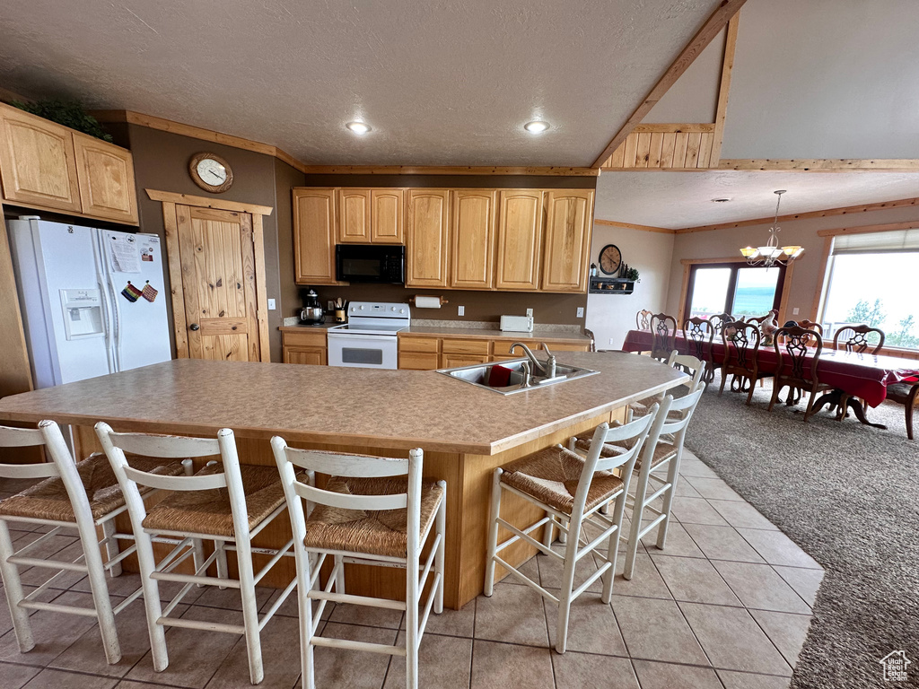 Kitchen with white appliances, a sink, light brown cabinets, a kitchen breakfast bar, and a textured ceiling