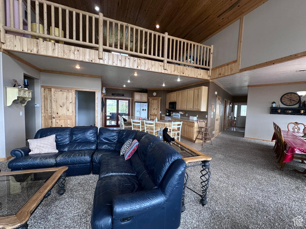 Carpeted living room with high vaulted ceiling, recessed lighting, and baseboards