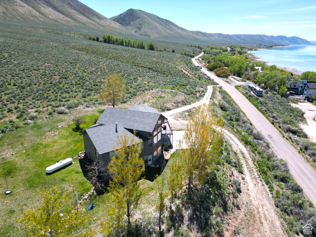 Aerial view of property and surrounding area with a water and mountain view