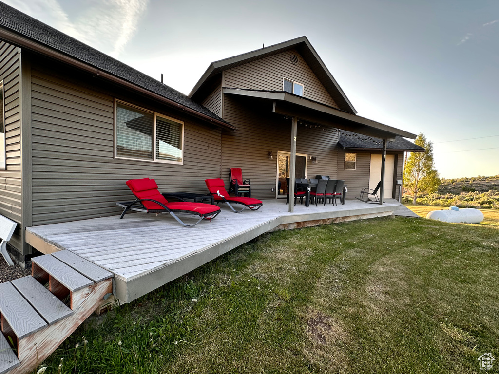 Rear view of house featuring a yard and a deck