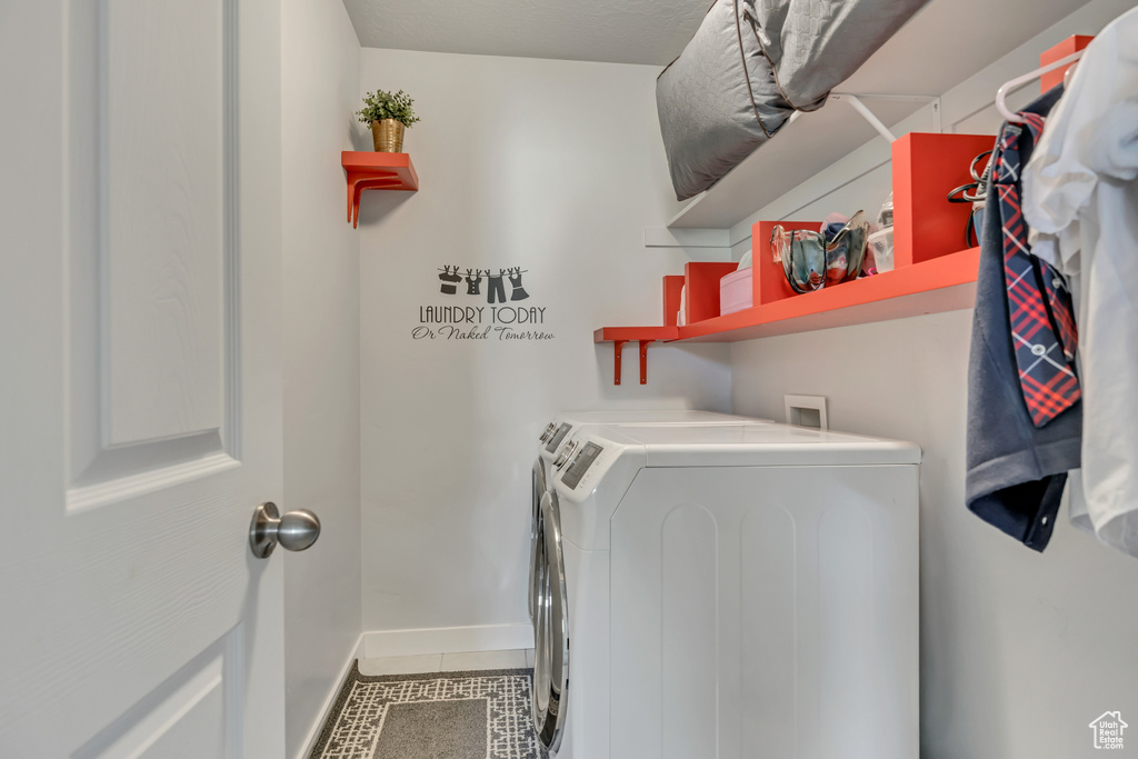 Laundry room with washer and dryer, tile patterned floors, and baseboards
