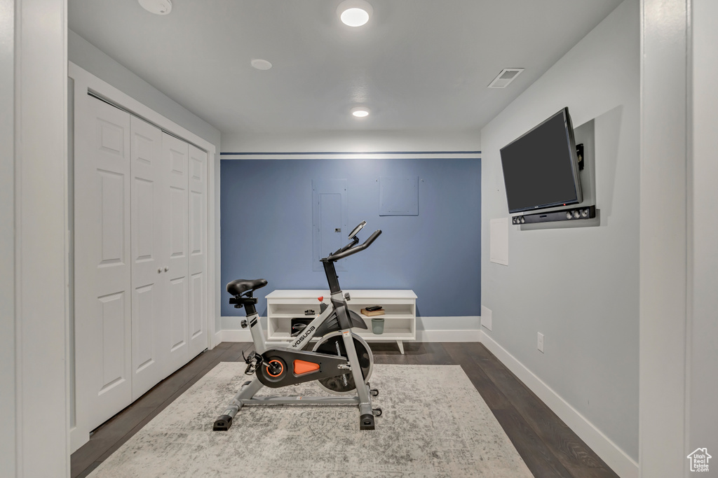 Exercise area featuring dark wood-style floors, baseboards, and recessed lighting