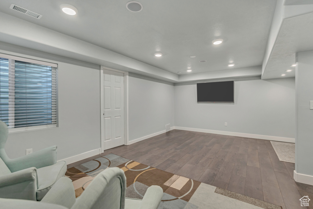 Finished below grade area with dark wood-style flooring, baseboards, and recessed lighting